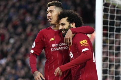 Liverpool's Mohamed Salah, right, celebrates with Liverpool's Roberto Firmino after scoring his sides third goal during the English Premier League soccer match between Liverpool and Southampton at Anfield Stadium, Liverpool, England, Saturday, February 1, 2020. (AP Photo/Jon Super)