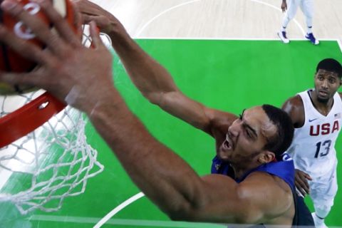 France's Rudy Gobert (16) dunks the ball over United States' Paul George (13) during a basketball game at the 2016 Summer Olympics in Rio de Janeiro, Brazil, Sunday, Aug. 14, 2016. (AP Photo/Charlie Neibergall)