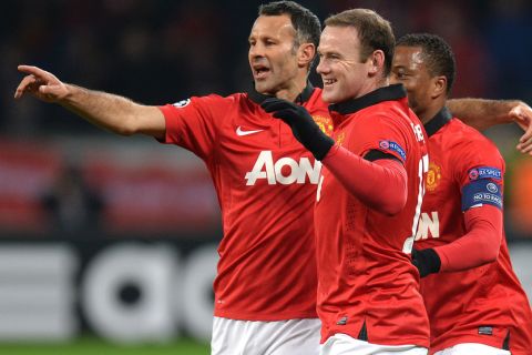 Manchester´s Ryan Giggs (L), Wayne Rooney (C) and Patrice Evra celebrate after the 0-2 during the UEFA Champions League Group A football match Bayern Leverkusen vs Manchester United in Leverkusen, western Germany on November 27, 2013. AFP PHOTO / PATRIK STOLLARZ        (Photo credit should read PATRIK STOLLARZ/AFP/Getty Images)
