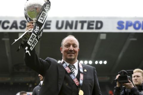 Newcastle United manager Rafa Benitez celebrates with the Championship trophy after they won their English Championship soccer match against Barnsley at St James' Park, Newcastle, England, Sunday, May 7, 2017. (Owen Humphreys/PA via AP)