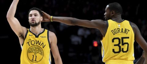 Golden State Warriors guard Klay Thompson, left, is patted on his head by forward Kevin Durant, right, after hitting a shot late in an NBA basketball game against the Portland Trail Blazers in Portland, Ore., Saturday, Dec. 29, 2018. The Warriors won 115-105. (AP Photo/Steve Dykes)