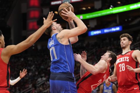 Dallas Mavericks' Luka Doncic (77) is fouled by Houston Rockets' Garrison Mathews (25) during the first half of an NBA basketball game Monday, Jan. 2, 2023, in Houston. (AP Photo/David J. Phillip)