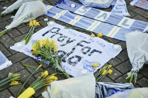 Flowers and tributes are placed outside Cardiff City Football Club, Wales, Wednesday Jan. 23, 2019, after a plane with new signing Emiliano Sala on board went missing over the English Channel on Monday night. The search resumed Wednesday to find missing Emiliano Sala and his pilot with authorities in the Channel Islands prioritizing whether they have been unable to make contact after more than 36 hours having managed to land, been picked up by a ship or are still on a lifeboat. (Ben Birchall/PA via AP)