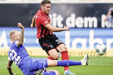 Freiburg's Christian Guenter, right, scores the opening goal during the German Bundesliga soccer match between TSG 1899 Hoffenheim and SC Freiburg in Sinsheim, Germany, Sunday, Sept, 15, 2019. Left are Hoffenheim's Kevin Vogt. (Uwe Anspach/dpa via AP)