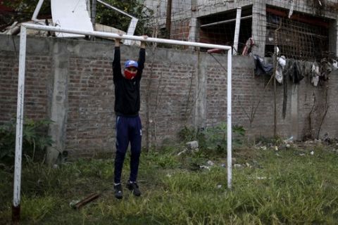 Nicolas Suarez, 16, poses for a photo as he hangs from a soccer goalpost in a soccer field that's closed due to the COVID-19 lockdown in the Fraga neighborhood of Buenos Aires, Argentina, Saturday, June 6, 2020. Suarez, who is recognized as one of the best players in his neighborhood, said that even though hes afraid of the virus he needs to keep playing, as he has aspirations to go professional. (AP Photo/Natacha Pisarenko)