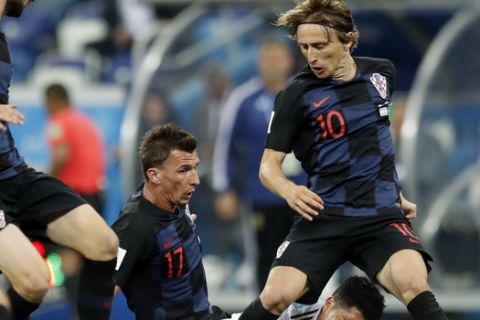 Argentina's Lucas Biglia, on the ground, fights for the ball with Croatia's Mario Mandzukic, left, and Luka Modric during the group D match between Argentina and Croatia at the 2018 soccer World Cup in Nizhny Novgorod Stadium in Novgorod, Russia, Thursday, June 21, 2018. (AP Photo/Pavel Golovkin)