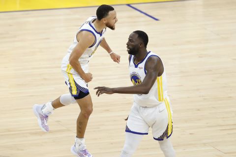 Golden State Warriors guard Stephen Curry, left, celebrates with forward Draymond Green during the first half of Game 1 of basketball's NBA Finals against the Boston Celtics in San Francisco, Thursday, June 2, 2022. (AP Photo/John Hefti)