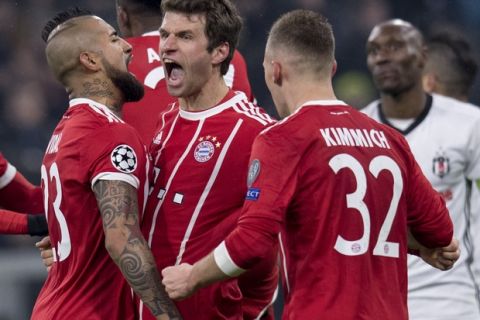 Bayern's Thomas Mueller is congratulated by his teammates Arturo Vidal, left, and  Joshua Kimmich, right, after scoring the opening goal during the Champions League round of 16 first leg soccer match between Bayern Munich and Besiktas Istanbul in Munich, southern Germany, Tuesday, Feb. 20, 2018.  (Sven Hoppe/dpa via AP)