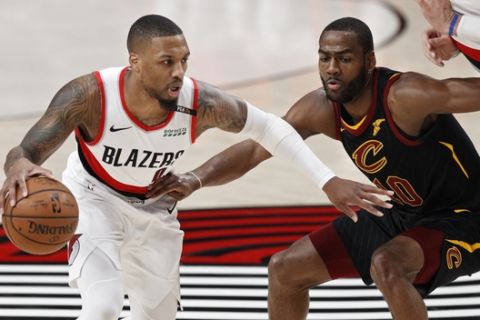 Portland Trail Blazers guard Damian Lillard, left, drives against Cleveland Cavaliers guard Alec Burks during the first half of an NBA basketball game in Portland, Ore., Wednesday, Jan. 16, 2019. (AP Photo/Steve Dipaola)