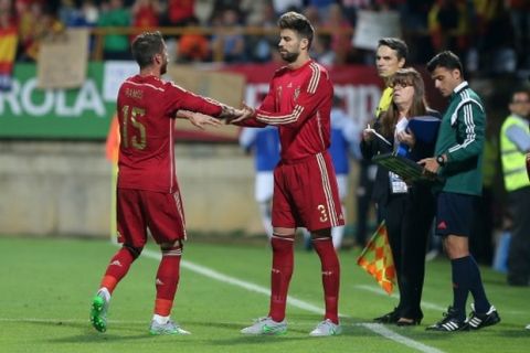 Spain's defender Sergio Ramos (L) greets teammate Spain's defender Gerard Pique during the friendly football match Spain vs Costa Rica at the Reino de Leon stadium in Leon on June 11, 2015. AFP PHOTO/ CESAR MANSO        (Photo credit should read CESAR MANSO/AFP/Getty Images)