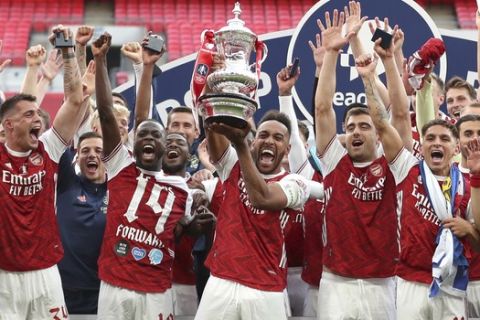 Arsenal's players celebrate with the trophy after the FA Cup final soccer match between Arsenal and Chelsea at Wembley stadium in London, England, Saturday, Aug.1, 2020. (Catherine Ivill/Pool via AP)