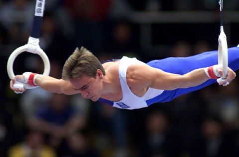 Greece's Dimosthenis Tambakos performs on the rings during the individual events at the Gymnastics World Championships in Tianjin, China, Friday October 15, 1999. Tambakos took the bronze medal, with China's Dong Zhen winning the gold and Hungary's Szilveszter Csollany the silver. (AP Photo/Greg Baker)