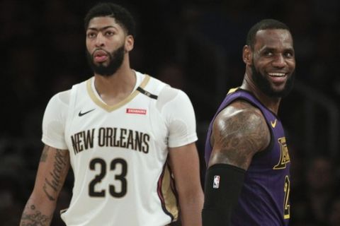 Los Angeles Lakers' LeBron James, right, smiles as he walks past New Orleans Pelicans' Anthony Davis during the first half of an NBA basketball game Friday, Dec. 21, 2018, in Los Angeles. (AP Photo/Jae C. Hong)