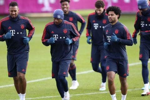 Bayern's Jerome Boateng, from left, David Alaba and Serge Gnabry warm up for a training session in Munich, Germany, Tuesday, Dec. 10, 2019 prior to the Champions League group B soccer match between Bayern Munich and Tottenham Hotspur. Bayern will face Tottenham on Wednesday. (AP Photo/Matthias Schrader)