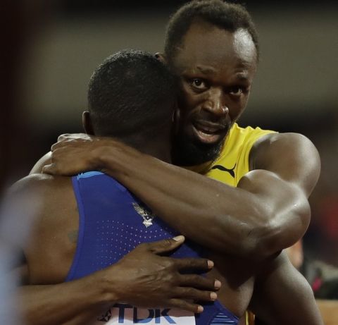 Jamaica's Usain Bolt, bronze, embraces gold medal winner United States' Justin Gatlin after the Men's 100m final during the World Athletics Championships in London, Saturday, Aug. 5, 2017. (AP Photo/David J. Phillip)