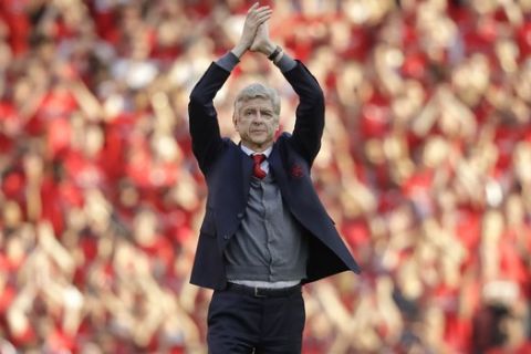Arsenal's French manager Arsene Wenger applauds before his lap of honor at the Emirates Stadium in London, Sunday, May 6, 2018. The match is Arsenal manager Arsene Wenger's last home game in charge after announcing in April he will stand down as Arsenal coach at the end of the season after nearly 22 years at the helm. (AP Photo/Matt Dunham)