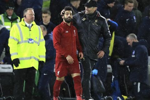 Liverpool manager Jurgen Klopp, right, and Mohamed Salah celebrate after the final whistle of the English Premier League soccer match between Brighton and Hove Albion and Liverpool F.C at the Amex Stadium, Brighton England. Saturday, Jan. 12, 2019. (Gareth Fuller/PA via AP)