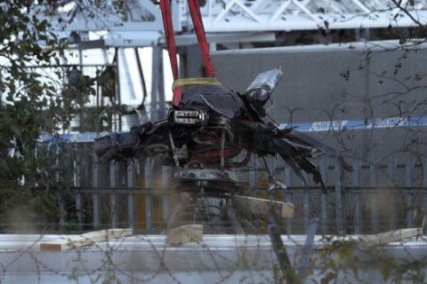 A crane moves part of the wreckage from the helicopter crash at Leicester City Football Club in Leicester, England, Thursday, Nov. 1, 2018. The son of the Leicester owner killed in a helicopter crash says he will honor his father by continuing his "big vision and dreams" at the Premier League club. Aiyawatt Srivaddhanaprabha posted a tribute to his father saying "from him, I have received a very big mission and legacy to pass on and I intend to do just that." (Aaron Chown/PA via AP)