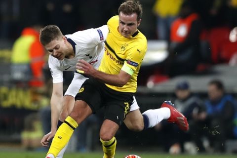 Tottenham defender Juan Foyth fights for the ball with Dortmund midfielder Mario Gotze, right, during the Champions League round of 16, first leg, soccer match between Tottenham Hotspur and Borussia Dortmund at Wembley stadium in London, Wednesday, Feb. 13, 2019. (AP Photo/Alastair Grant)