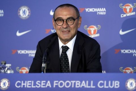 Maurizio Sarri, the new Chelsea football team manager, smiles at a press conference to introduce him at Stamford Bridge stadium in London, Wednesday, July 18, 2018. (AP Photo/Kirsty Wigglesworth)