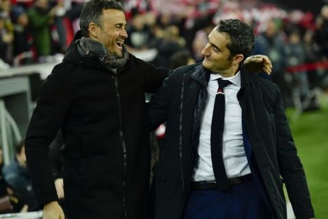 FILE- In this Thursday, Jan.5, 2017 file photo, Barcelona's manager Luis Enrique, left smiles beside Athletic Bilbao's manager Ernesto Valverde, during the Spanish Copa del Rey, 16 round, first leg soccer match, between FC Barcelona and Athletic Bilbao, at San Mames stadium, in Bilbao, northern Spain. Barcelona said Monday, May 29, 2017, it has hired former player Ernesto Valverde as its new coach. (AP Photo/Alvaro Barrientos, File)