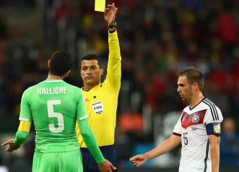 PORTO ALEGRE, BRAZIL - JUNE 30: Rafik Halliche of Algeria is shown a yellow card by referee Sandro Ricci as Philipp Lahm of Germany looks on during the 2014 FIFA World Cup Brazil Round of 16 match between Germany and Algeria at Estadio Beira-Rio on June 30, 2014 in Porto Alegre, Brazil.  (Photo by Julian Finney/Getty Images)