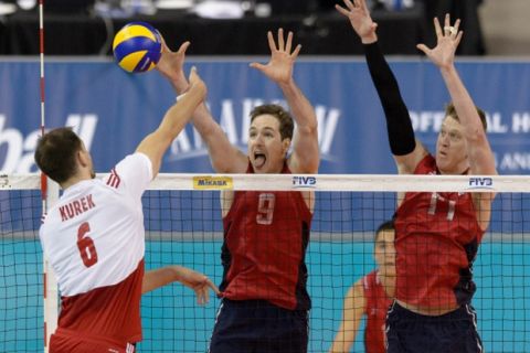 Hoffman Estates, IL, USA, June 12, 2015:  Polands Bartosz Kurek (6) spikes while USAs Troy Murphy (9) and USAs Maxwell Holt (17) block during a FIVB Men's Volleyball World League match between the United States and Poland at the Sears Centre Arena. Photographer: Daniel Bartel