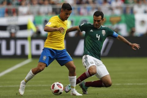Brazil's Philippe Coutinho, left, and Mexico's Rafael Marquez challenge for the ball during the round of 16 match between Brazil and Mexico at the 2018 soccer World Cup in the Samara Arena, in Samara, Russia, Monday, July 2, 2018. (AP Photo/Frank Augstein)