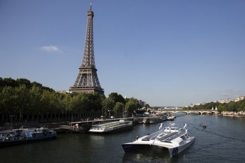 FILE- In this Tuesday, July 4, 2017 file photo, the Energy Observer, a former race boat turned into a autonomous navigation with hydrogen, sails past the Eiffel Tower on the Seine river in Paris. A boat that fuels itself is setting off from Paris on a six-year, round-the-world journey that its designers hope serves as a model for emissions-free energy networks of the future. (AP Photo/Kamil Zihnioglu, File)
