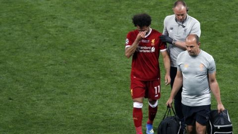 Liverpool's Mohamed Salah leaves the pitch after a collision with Real Madrid's Sergio Ramos during the Champions League Final soccer match between Real Madrid and Liverpool at the Olimpiyskiy Stadium in Kiev, Ukraine, Saturday, May 26, 2018. (AP Photo/Darko Vojinovic)