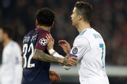 PSG's Dani Alves, left, holds Real Madrid's Cristiano Ronaldo during the round of 16, 2nd leg Champions League soccer match between Paris Saint-Germain and Real Madrid at the Parc des Princes Stadium in Paris, Tuesday, March 6, 2018. (AP Photo/Francois Mori)