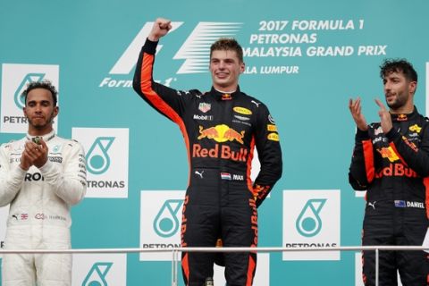 Race winner Red Bull driver Max Verstappen of the Netherlands waves on the podium with second placed Mercedes driver Lewis Hamilton, left, of Britain and third placed teammate Daniel Ricciardo, right, of Australia at the Malaysian Formula One Grand Prix at the Sepang International Circuit in Sepang, Malaysia, Sunday, Oct. 1, 2017. (AP Photo/Vincent Thian)
