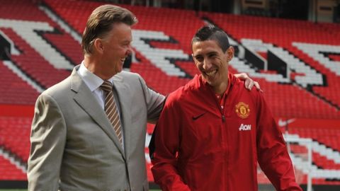 Manchester United's Dutch manager Louis van Gaal (L) walks with Manchester United's newly-signed Argentinian midfielder Angel di Maria (R) during an official presentation on the pitch at Old Trafford in Manchester, north-west England on August 28, 2014. Manchester United announced on August 26, 2014 that they have signed Argentina winger Angel di Maria from Real Madrid for a British-record transfer fee of 59.7 million GBP (98 million USD, 75 million euros).  AFP PHOTO / STEVE PARKIN  --  RESTRICTED TO EDITORIAL USE. No use with unauthorized audio, video, data, fixture lists, club/league logos or live services. Online in-match use limited to 45 images, no video emulation. No use in betting, games or single club/league/player publications.        (Photo credit should read steve parkin/AFP/Getty Images)