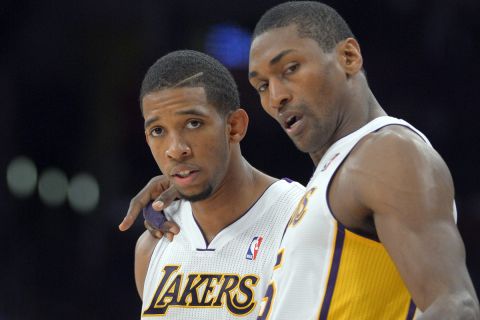 Los Angeles Lakers guard Darius Morris, left, talks with forward Metta World Peace during the first half of their NBA basketball game against the Houston Rockets, Sunday, Nov. 18, 2012, in Los Angeles. (AP Photo/Mark J. Terrill) 