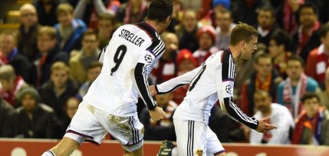 Basel's Swiss midfielder Fabian Frei (R) celebrates scoring the opening goal during the UEFA Champions League group B football match between Liverpool and Basel at Anfield in Liverpool, north west England, on December 9, 2014.  AFP PHOTO / PAUL ELLIS        (Photo credit should read PAUL ELLIS/AFP/Getty Images)