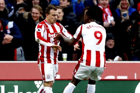 Stoke City's Xherdan Shaqiri celebrates scoring his side's first goal of the game with team mate Saido Berahino during the English Premier League soccer match between Stoke City and Brighton and Hove Albion at the bet365 Stadium, Stoke, England. Saturday Feb. 10, 2018.(Martin Rickett/PA via AP)