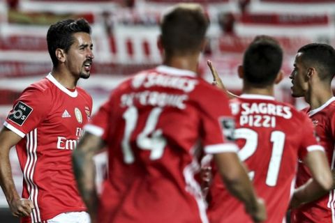 Benfica's Andre Almeida, left, celebrates after scoring the opening goal during the Portuguese League soccer match between Benfica and Boavista at the Luz stadium in Lisbon, Portugal, Saturday, July 4, 2020. The Portuguese League soccer matches are being played without spectators because of the coronavirus pandemic. (Manuel de Almeida/Pool via AP)
