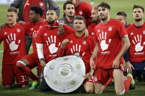 Bayern's players pose with a mock trophy as they celebrate winning the German soccer champion title after the Bundesliga soccer match against VfL Wolfsburg in Wolfsburg, Germany, Saturday, April 29, 2017. (AP Photo/Michael Sohn)