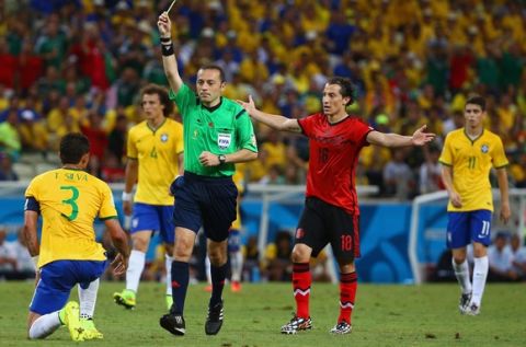 FORTALEZA, BRAZIL - JUNE 17:  Referee Cuneyt Cakir shows a yellow card to Thiago Silva of Brazil as Andres Guardado of Mexico reacts during the 2014 FIFA World Cup Brazil Group A match between Brazil and Mexico at Castelao on June 17, 2014 in Fortaleza, Brazil.  (Photo by Robert Cianflone/Getty Images)