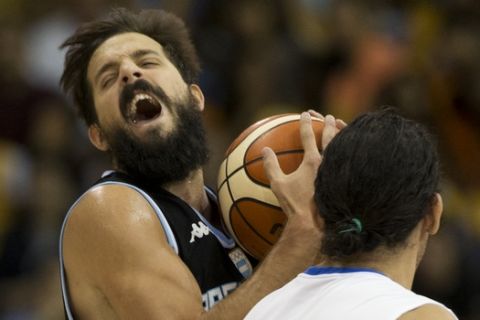 Argentina's Nicolas Laprovittola , left, battles with Dominican Republc's Manuel Guzman, front, during their preliminary men's basketball game at the Pan Am Games in Toronto, Thursday, July 23, 2015. (AP Photo/Rebecca Blackwell)