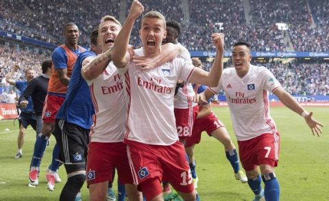 From left: Hamburg's Lewis Holtby, Gian-Luca Waldschmidt and Bobby Wood  celebrate Waldschmidt's goal during the German Bundesliga soccer match between Hamburger SV and VfL Wolfsburg in Hamburg, Germany, Saturday, May 20, 2017.  Gian-Luca Waldschmidt scored one day after his 21st birthday for Hamburger SV to clinch Bundesliga survival with a late 2-1 win over Wolfsburg on the final day of the season Saturday.  (Christian Charisius/dpa via AP)