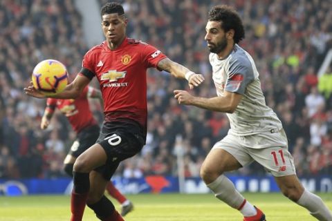 Manchester United's Marcus Rashford, left, and Liverpool's Mohamed Salah challenge for the ball during the English Premier League soccer match between Manchester United and Liverpool at Old Trafford stadium in Manchester, England, Sunday, Feb. 24, 2019. (AP Photo/Jon Super)