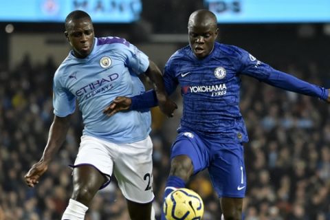 Chelsea's N'Golo Kante, right, controls the ball to shoot and score the opening goal nest to Manchester City's Benjamin Mendy, left, during the English Premier League soccer match between Manchester City and Chelsea at Etihad stadium in Manchester, England, Saturday, Nov. 23, 2019. (AP Photo/Rui Vieira)