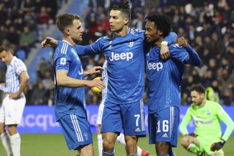 Juventus' Cristiano Ronaldo, center, celebrates with teammates Juan Cuadrado, right, and Aaron Ramsey after scoring his side's first goal, during an Italian Serie A soccer match between Spal and Juventus at the Paolo Mazza stadium in Ferrara, Italy, Saturday, Feb. 22, 2020. (Filippo Rubin/LaPresse via AP)