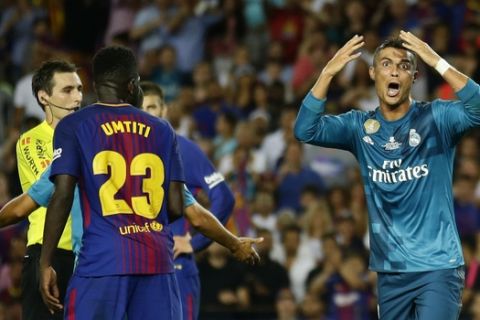 Real Madrid's Cristiano Ronaldo, right, reacts after Referee Ricardo de Burgos, left, shows a second yellow card during the Spanish Supercup, first leg, soccer match between FC Barcelona and Real Madrid at the Camp Nou stadium in Barcelona, Spain, Sunday, Aug. 13, 2017. Cristiano Ronaldo was banned for five games on Monday after shoving a referee following his red card for diving in Real Madrid's 3-1 win over Barcelona in the season-opening Spanish Super Cup. (AP Photo/Manu Fernandez)