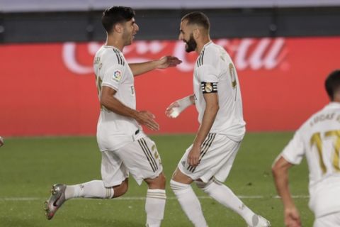 Real Madrid's Karim Benzema, right, celebrates after scoring a penalty against Deportivo Alaves with his teammate Marco Asensio during the Spanish La Liga soccer match between Real Madrid and Deportivo Alaves at the Alfredo di Stefano stadium in Madrid, Spain, Friday, July 10, 2020. (AP Photo/Bernat Armangue)
