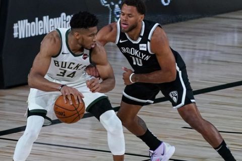Brooklyn Nets guard Justin Anderson (10) defends Milwaukee Bucks forward Giannis Antetokounmpo (34) during the first half of an NBA basketball game Tuesday, Aug. 4, 2020 in Lake Buena Vista, Fla. (AP Photo/Ashley Landis)