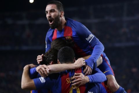 Barcelona's Arda Turan, top, celebrates with his teammates after Luis Suarez, foreground, scored the opening goal during the the Copa del Rey semifinal second leg soccer match between FC Barcelona and Atletico Madrid at the Camp Nou stadium in Barcelona, Spain, Tuesday Feb. 7, 2017. (AP Photo/Manu Fernandez)