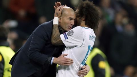 Real Madrid's Marcelo celebrates his side's 3rd goal with his head coach Zinedine Zidane during a Champions League Round of 16 first leg soccer match between Real Madrid and Paris Saint Germain at the Santiago Bernabeu stadium in Madrid, Spain, Wednesday, Feb. 14, 2018. (AP Photo/Francisco Seco)