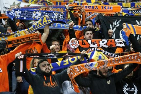 APOEL Nicosia fans shoot slogans as they hold scarfs of their team during the Champions League Group C soccer match between Tottenham and APOEL Nicosia, in London, Wednesday, Dec. 6, 2017. (AP Photo/Frank Augstein)